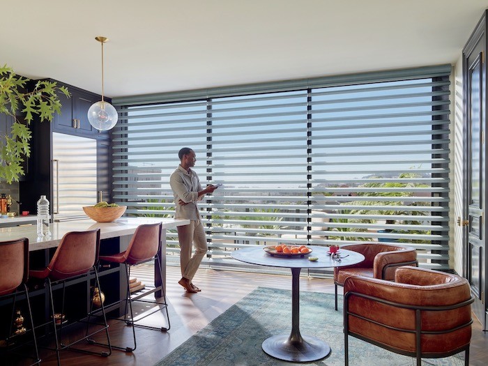 Kitchen with man using phone to operate shade